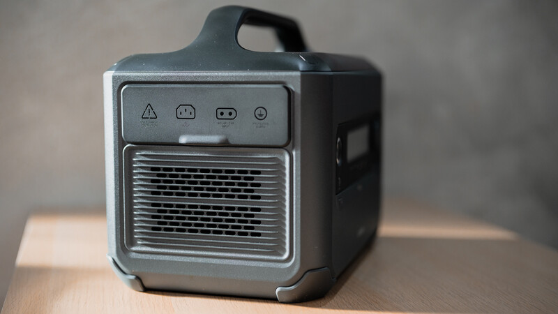 Black compact heating device with ventilation grille and control panel on wooden surface.