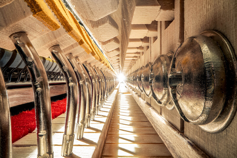 Symmetrical view down a long industrial laundry facility with rows of washing machines lining both sides.