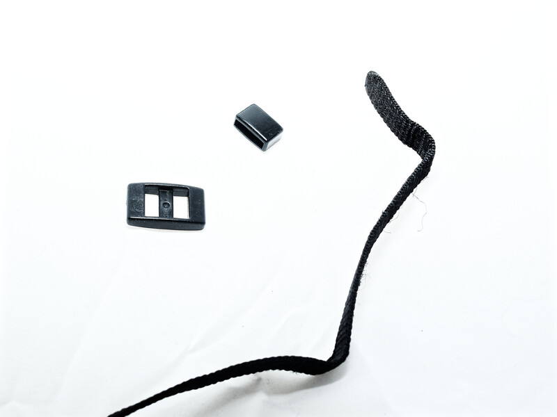 Black cable with textured grip end and two small plastic connector pieces on white background.