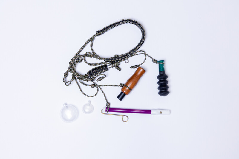 Flat lay of camera stabilization equipment including a gimbal with braided cable, dampening springs, and cylindrical components.