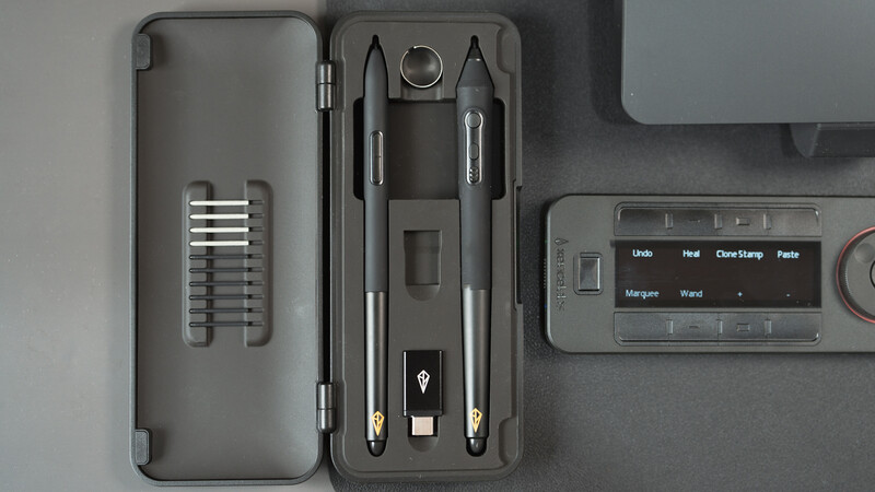 Overhead view of photography tools including lens cleaning supplies, brushes, and a digital light meter.