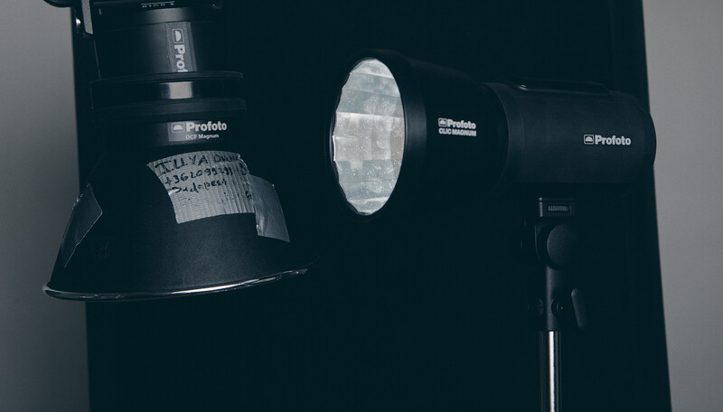 Profoto studio lighting equipment arranged against dark background with reflector and modifier visible.