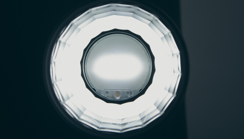 Overhead view of a circular ring light with white diffuser panel and dark center dome against dark background.