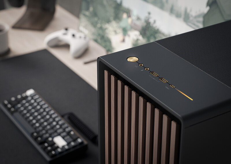 Modern black desktop tower with vertical ventilation slats and gold accent light on top.