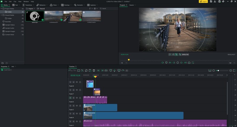Screenshot of video editing software showing a timeline with color-graded clips and a preview of a cyclist on a waterfront bridge.