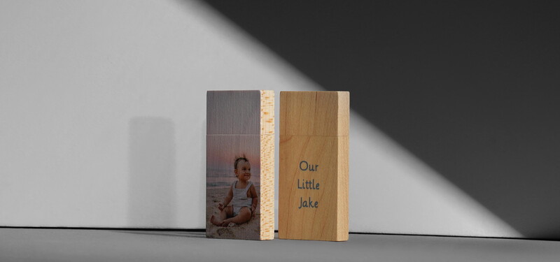 Two wooden photo blocks displayed against a white wall with dramatic shadow. Left block features a photograph, right block has engraved text.