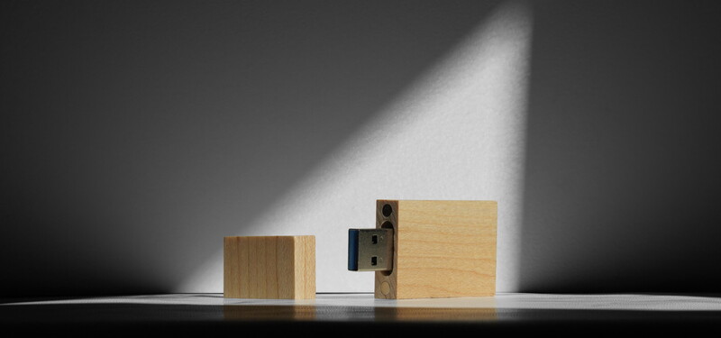 Two wooden blocks with an exposed door lock mechanism between them, lit by dramatic directional light.