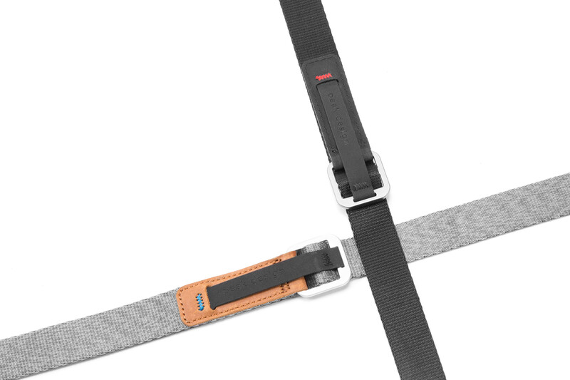 Two camera straps crossed in an X formation against a white background.