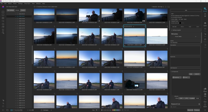 Screenshot of photo management software displaying a grid of landscape photographs with a silhouetted figure.