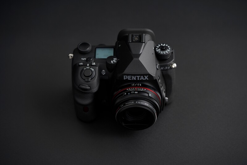 Pentax 67II medium format camera with light meter and lens attached, photographed from above against dark background.