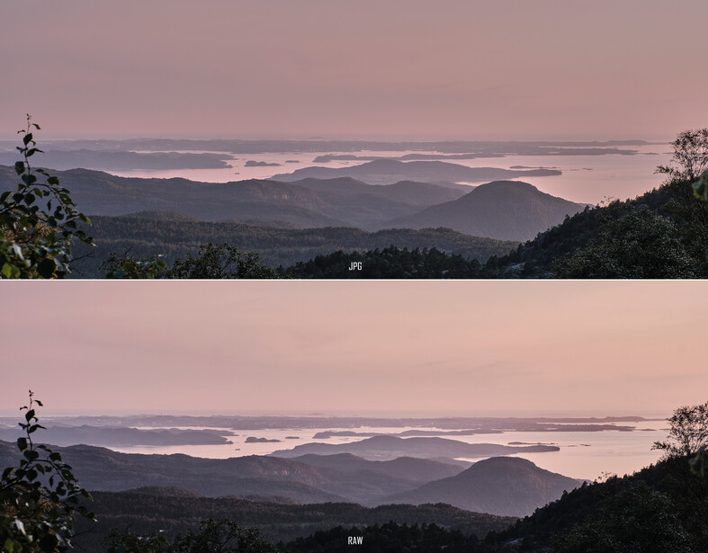 Layered mountain ridges receding into hazy distance under soft dawn or dusk light with pink and purple tones.