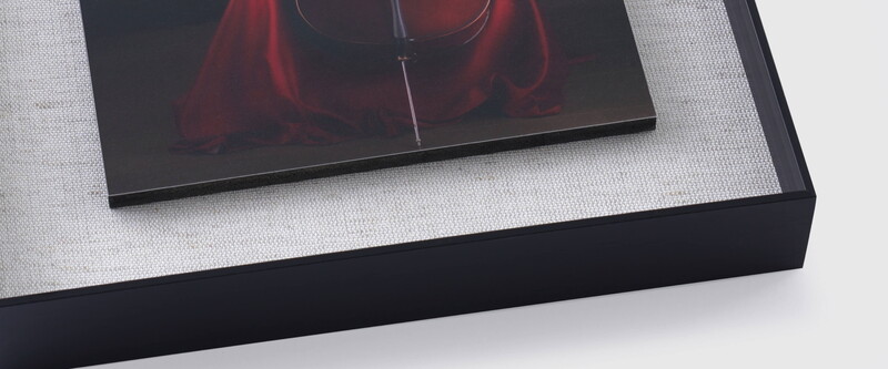 Close-up of a display device showing a portrait of a figure in red fabric against dark background.