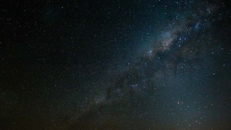 Milky Way galaxy stretching diagonally across a dark night sky filled with stars.