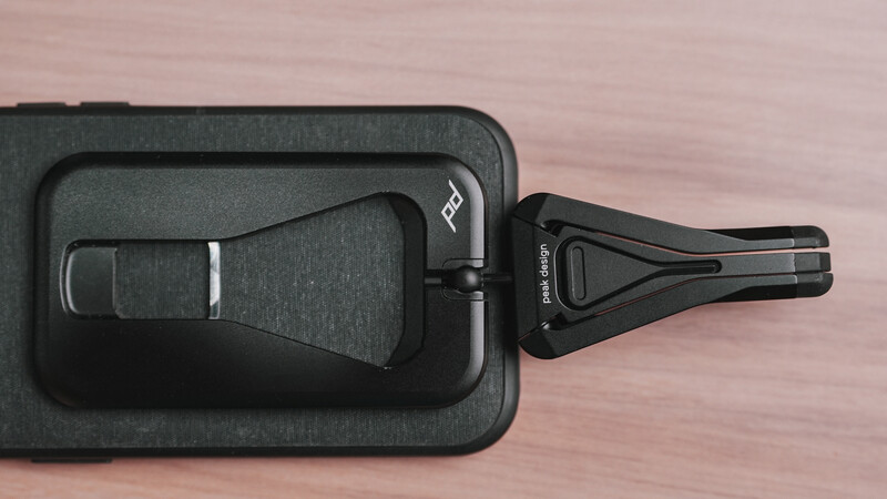 Black luggage tag with fabric insert displayed open on wooden surface.