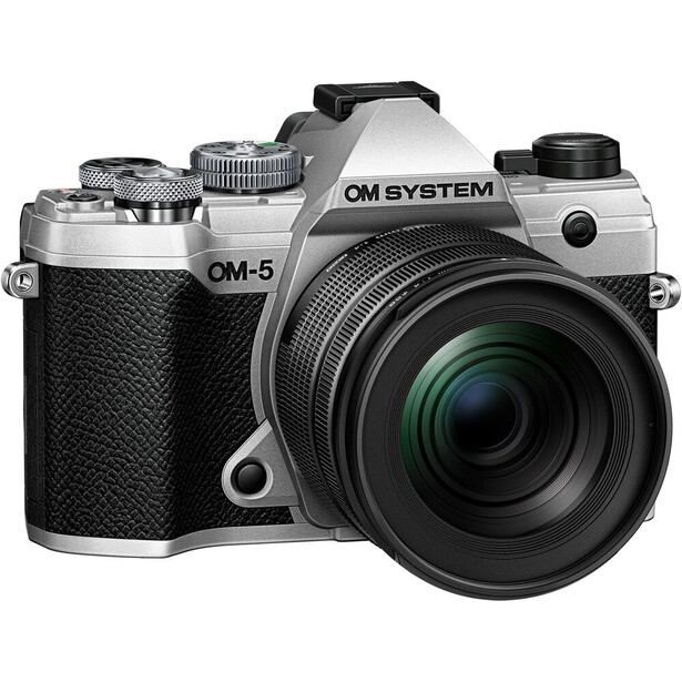 OM System OM-5 mirrorless camera with silver body and black leather grip, equipped with a green-tinted zoom lens.