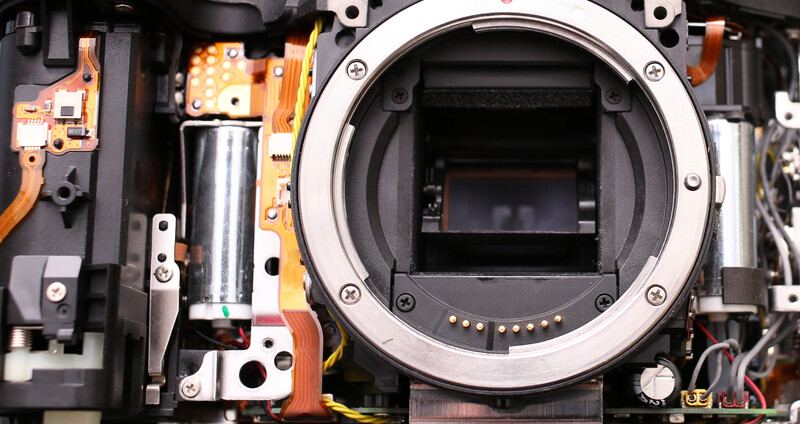 Interior view of a camera body with mirror removed, showing the sensor, mirror box assembly, and electronic components.