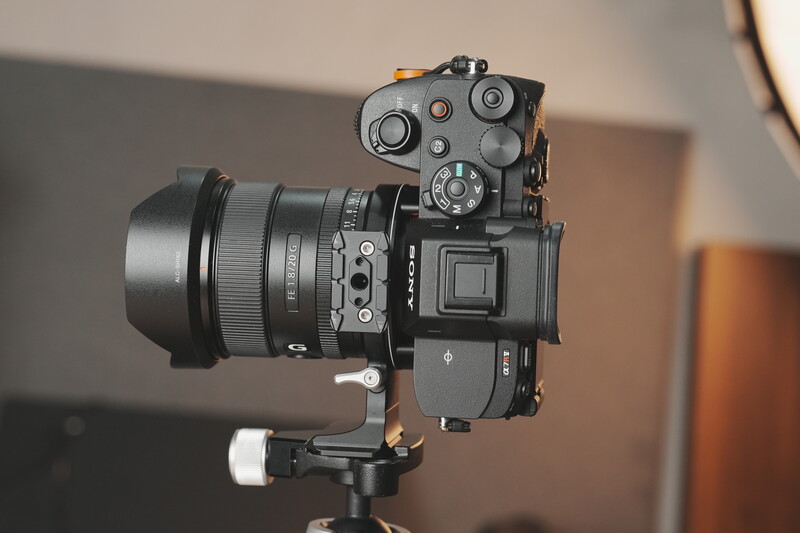 Mirrorless camera with standard zoom lens mounted on tripod with ball head.
