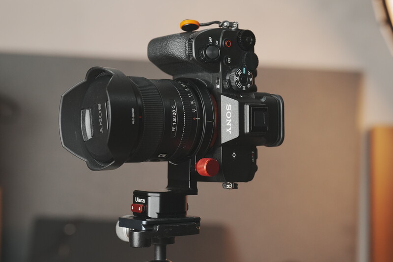 Sony mirrorless camera with wide-angle lens mounted on fluid head tripod, positioned for video work.