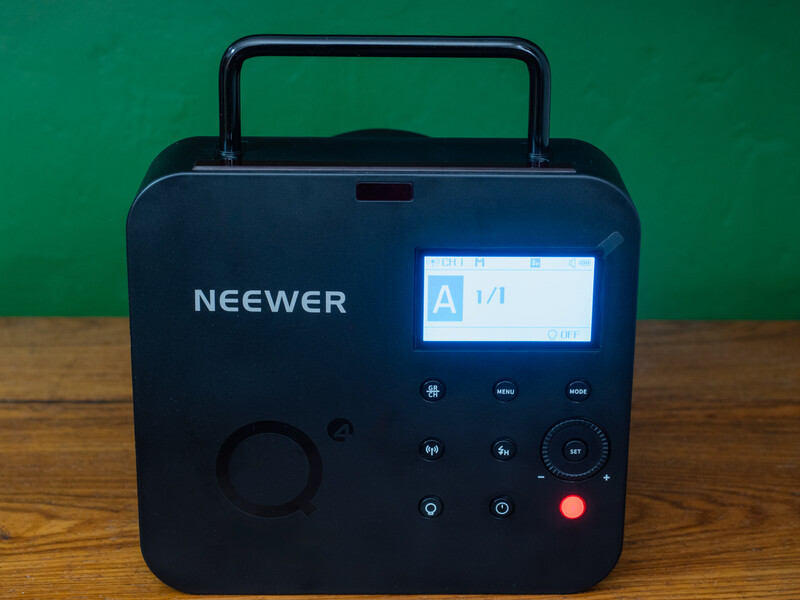 Neewer portable power station with LCD display, control buttons, and carry handle against green background.
