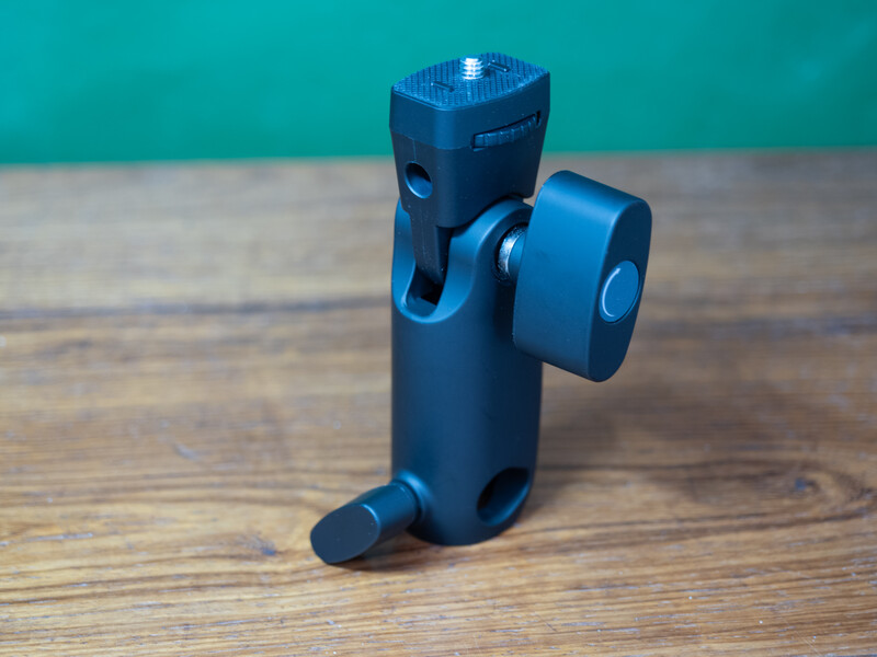 Blue camera ball head tripod mount with friction arms and quick-release plate on wooden surface.