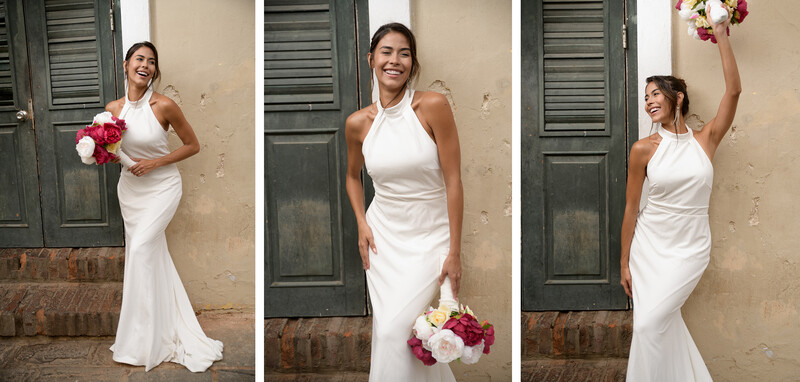Bride in white halter wedding dress posing with pink and red bouquet against textured wall.