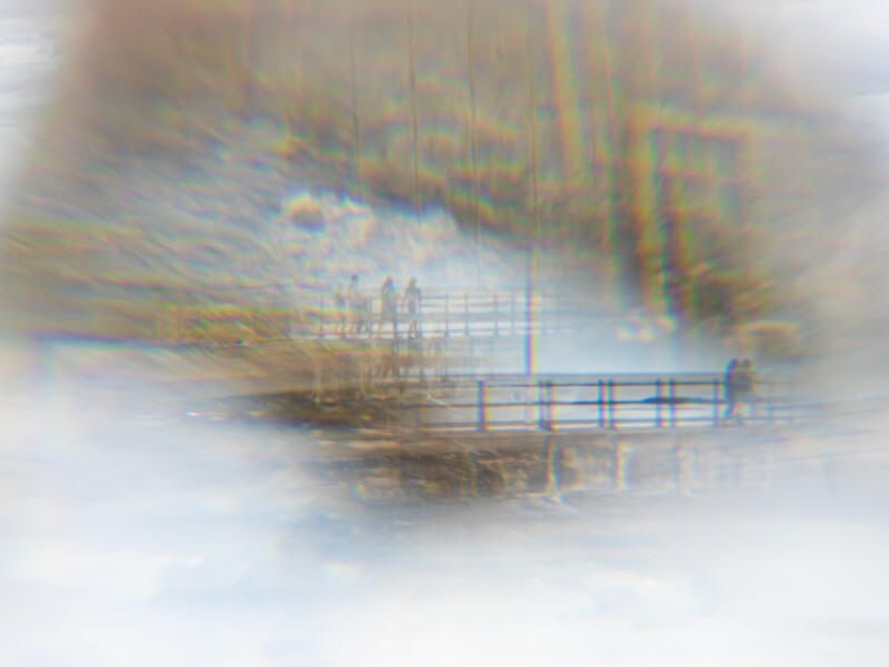 Double exposure photograph blending a wooden pier with autumn foliage and misty landscape.