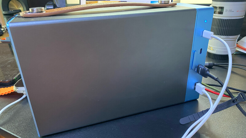 Blue and gray portable hard drive or external storage device with cables connected to the right side.