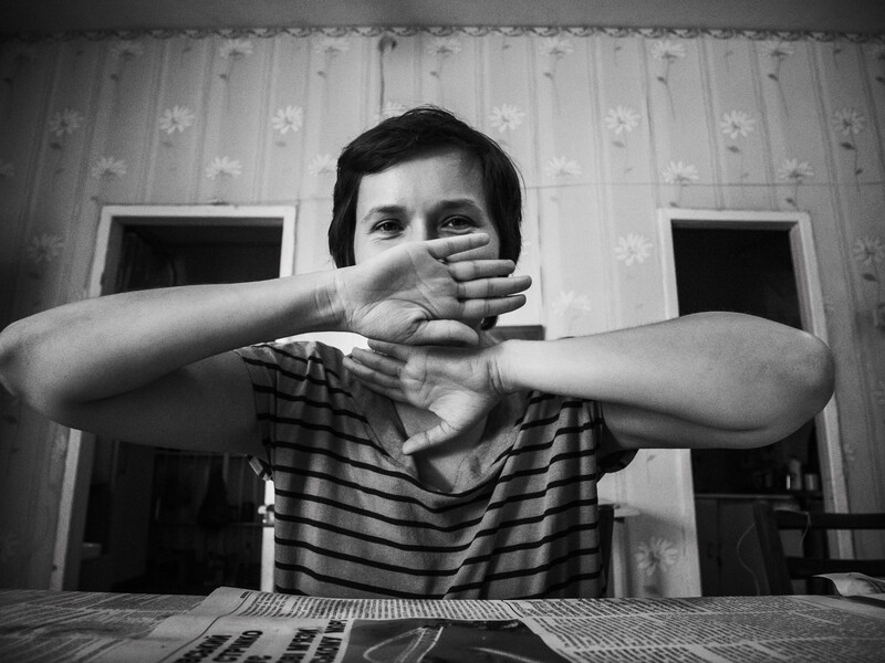 Young person in striped shirt making an X gesture with their arms crossed over their face.