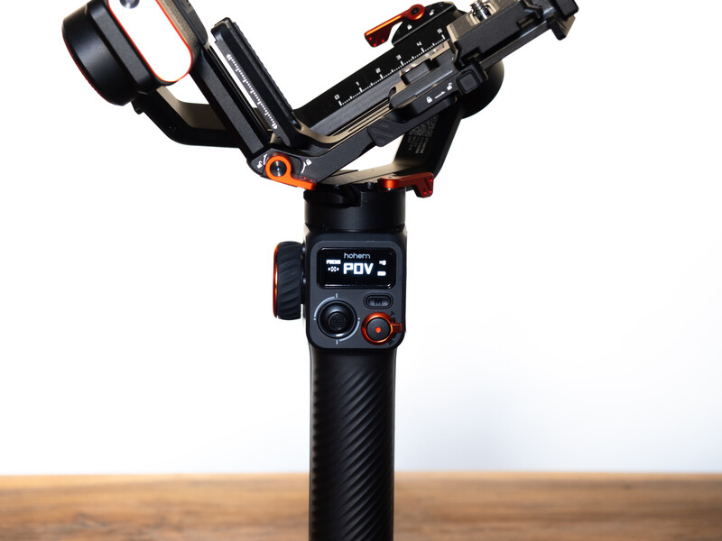 Three-axis gimbal stabilizer with camera mounted on top, displayed against a neutral background.