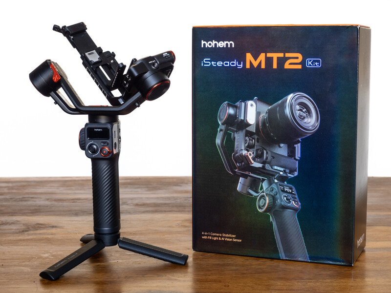 Bohem iSteady MT2 camera gimbal with stabilizer head mounted on tripod stand next to product packaging box.