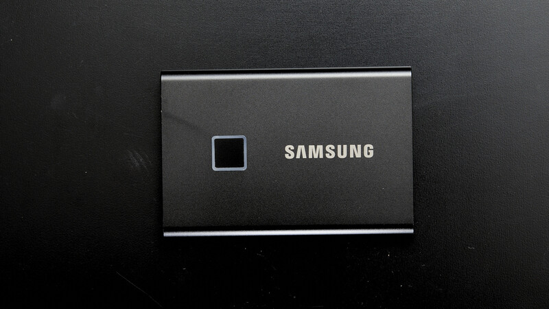 Samsung T7 portable SSD with loading indicator on dark display.