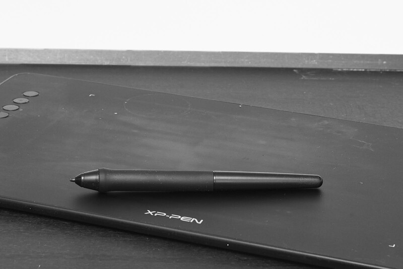 XP-Pen digital graphics tablet with stylus pen positioned on its black surface.