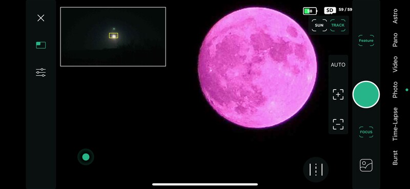 Screenshot of a mobile photography app displaying a bright magenta moon with lunar surface detail against a black background.