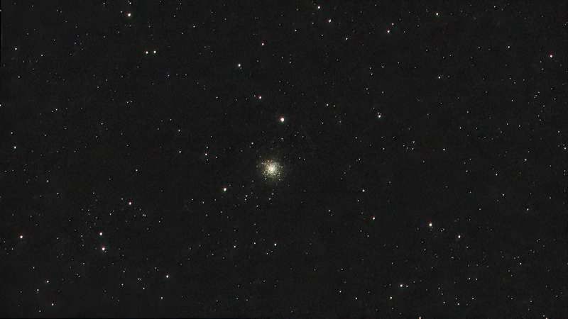 Globular star cluster with dense core surrounded by scattered stars against dark night sky.