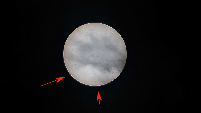 Full moon against black sky with red arrows indicating direction of movement or positioning.