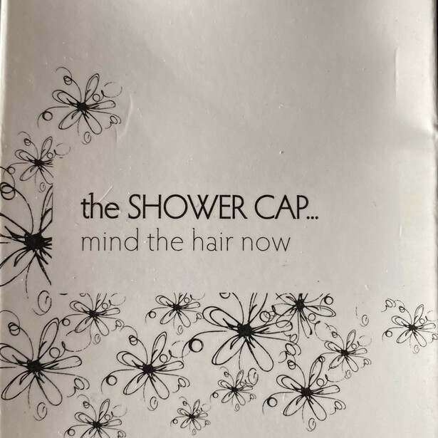 Graphic design with decorative floral pattern and text about shower caps and hair care.