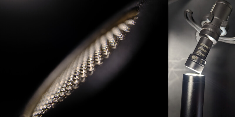 Close-up macro photography of a feather's detailed barbs and rachis against dark background.