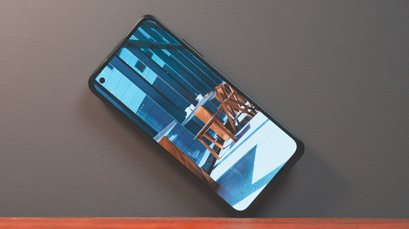 Smartphone displaying a modern architectural photograph with blue sky and orange structural elements.