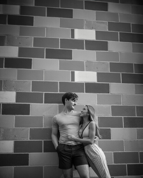 Couple embracing near a brick wall