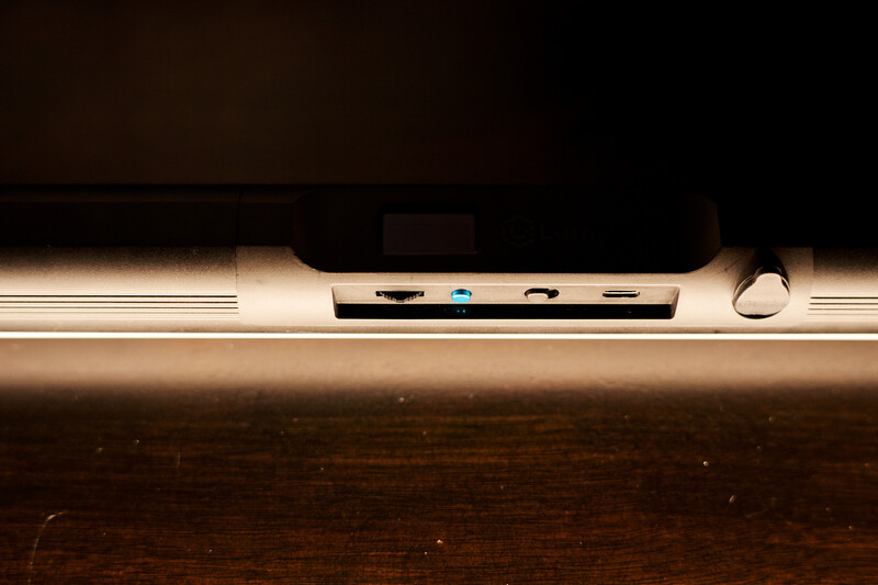 Top view of a modern laptop showing ports and connectors along the edge against a wooden surface.