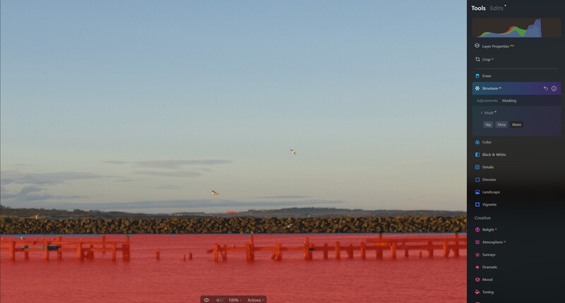 Screenshot of editing software showing landscape with red overlay and adjustment panels on right side.