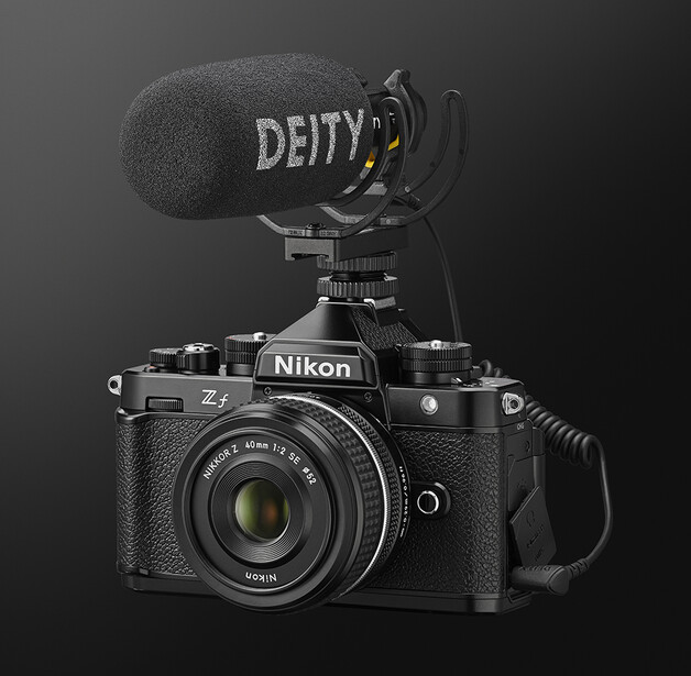 Nikon Z mirrorless camera with Deity microphone mounted on top against dark background.