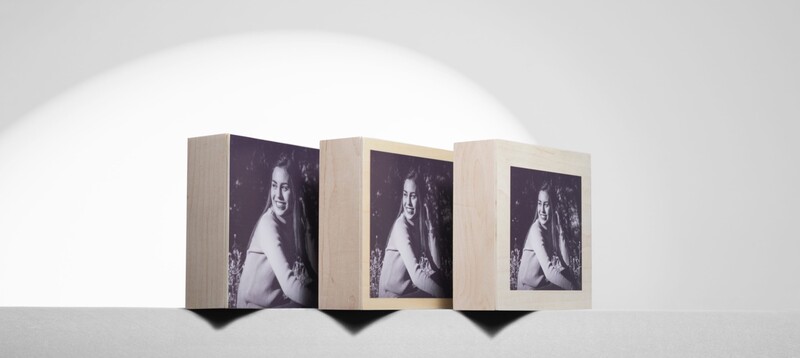 Three wooden photo blocks displaying black and white portrait prints of a woman arranged in a row.