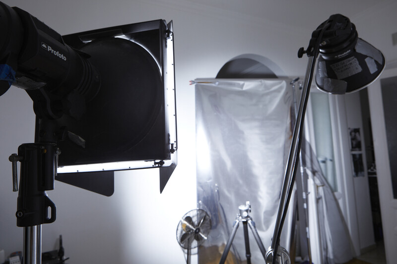Professional studio lighting setup with softbox, reflector, and key light positioned against neutral backdrop.