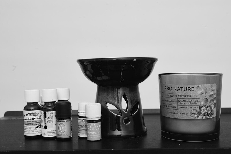 Monochrome flat lay of skincare and beauty products arranged on a black surface against a light gray backdrop.