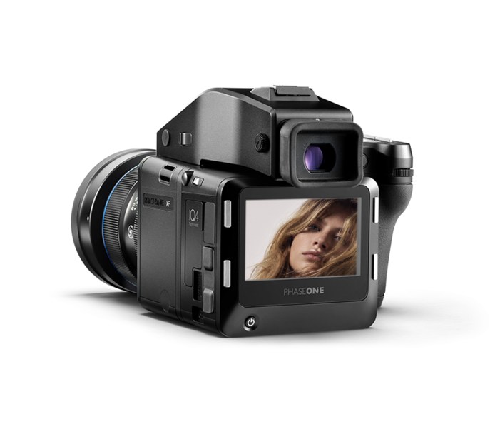 Medium format digital camera with interchangeable lens displayed at three-quarter angle, showing rear LCD screen with portrait preview.