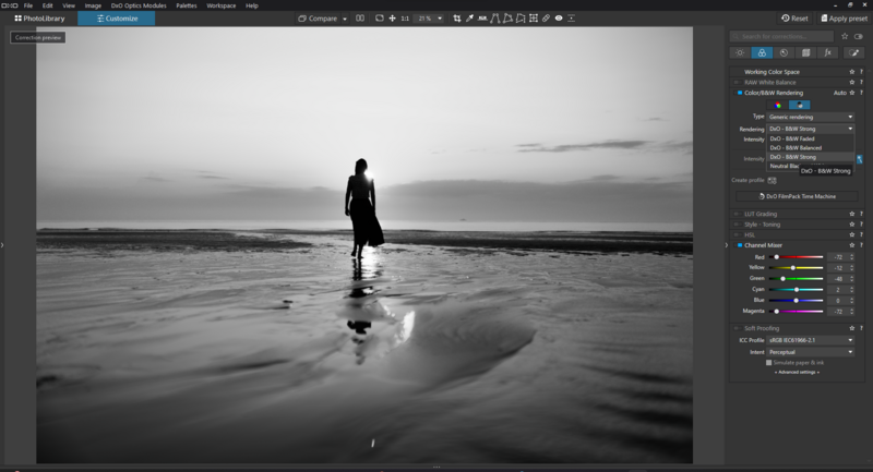 Silhouetted figure standing in shallow ocean water at dusk, with dramatic sky reflected in wet sand.