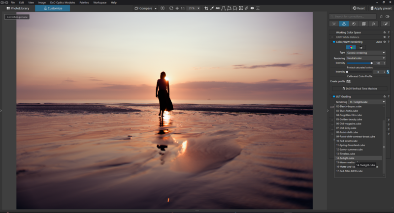 Silhouetted figure standing in shallow ocean water at sunset with golden light reflecting off the wet sand.