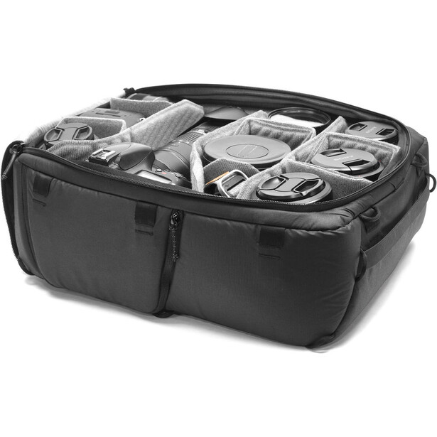 Black camera backpack with modular dividers displaying photography gear inside.