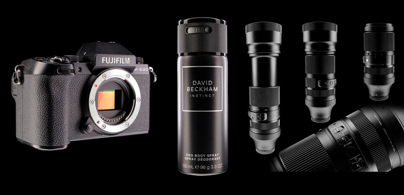 Fujifilm X-T5 mirrorless camera body next to David Beckham body spray and several telephoto lenses.